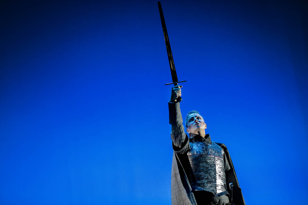 Kobieta w długiej sukni z wyciągniętą dłonią, w której trzyma miecz rycerski.