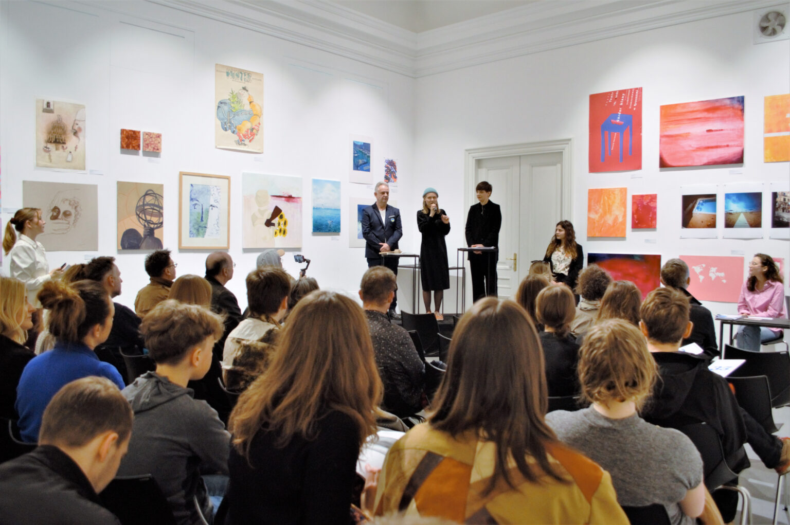 Uczestnicy aukcji obserwują trójkę prowadzących licytację