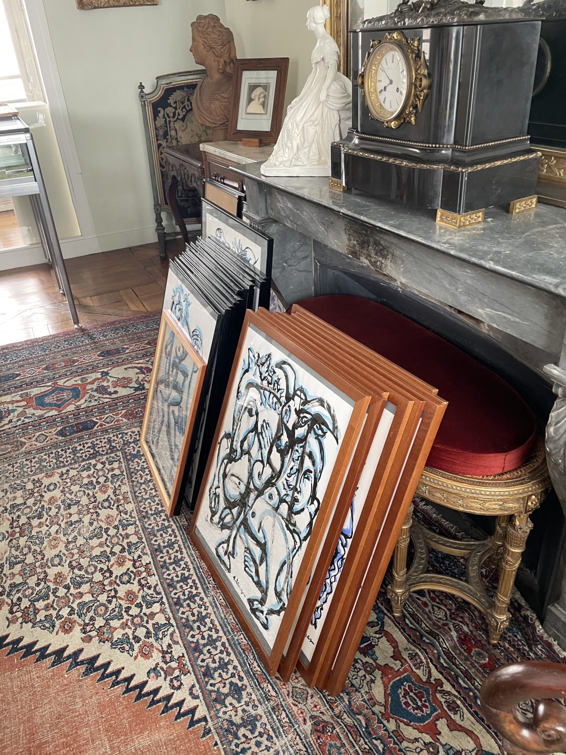 Obrazy w ramach oparte o szary marmurowy stół.