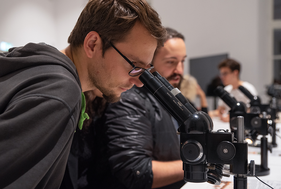 Mężczyzna patrzy przez mikroskop