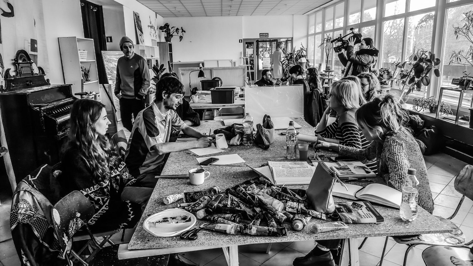 Młodzi ludzie siedzą przy stole w sali dydaktycznej