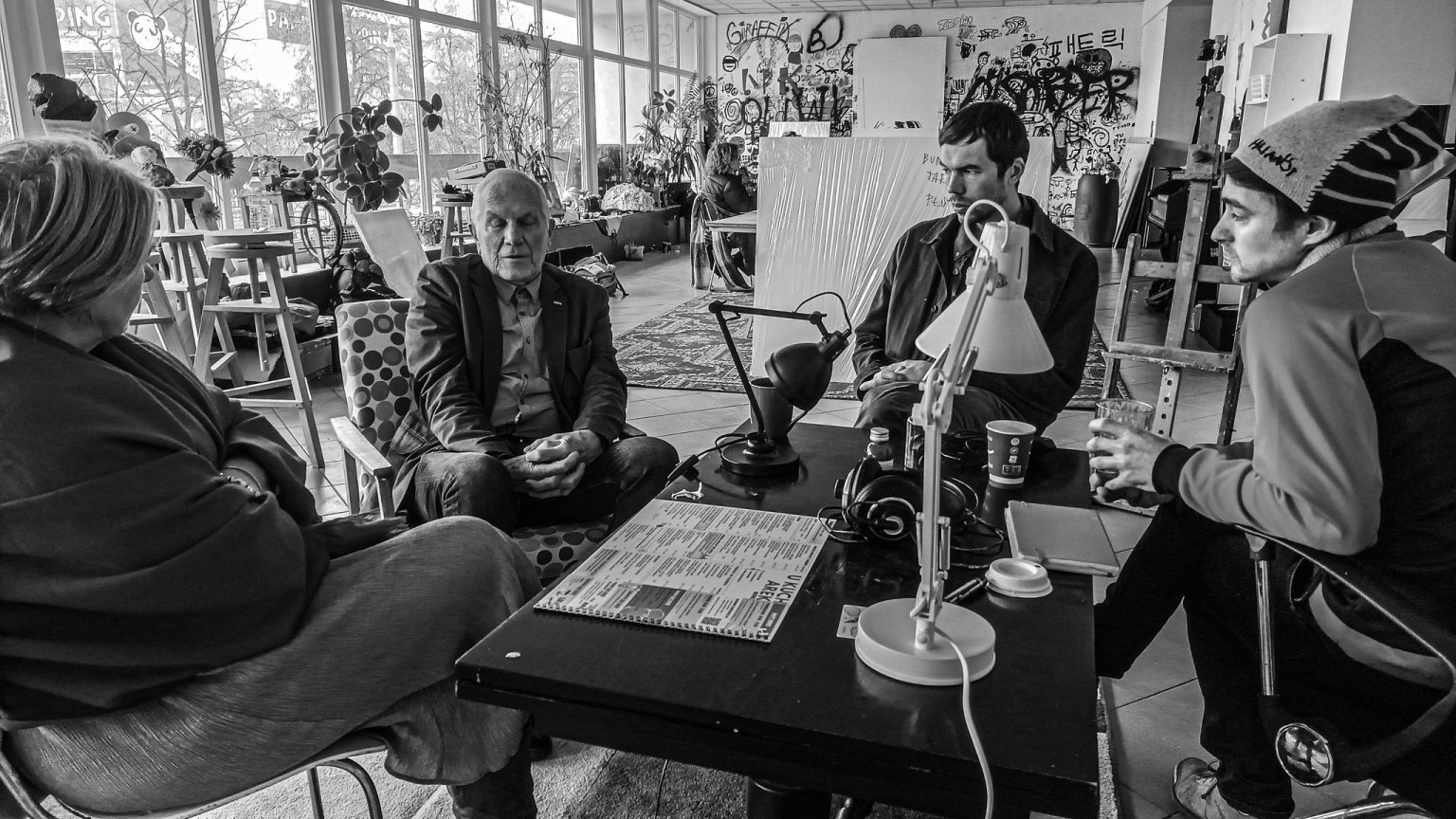 Młodzi ludzie siedzący przy stoliku wraz z wykładowcą