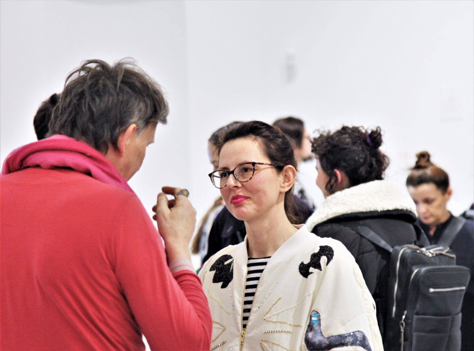 Uczestnicy wernisażu, mężczyzna i kobieta zajęci rozmową