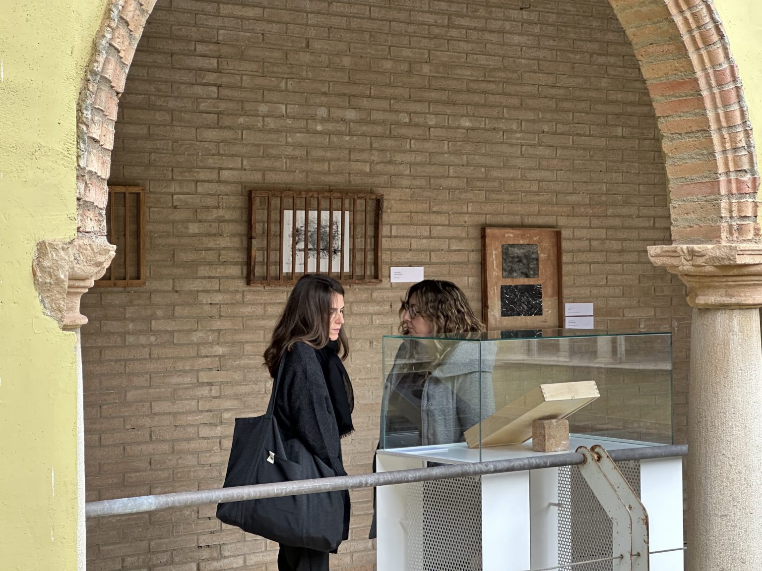 Dwie kobiety rozmawiające obok gabloty z eksponatem