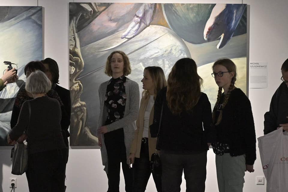 Grupa ludzi na wernisażu.