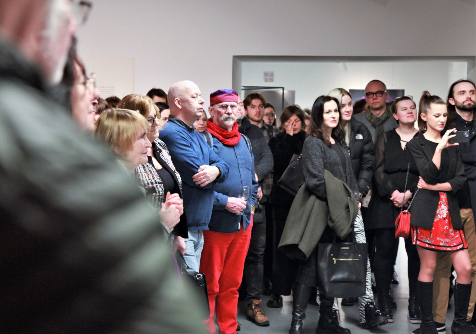 Goscie wernisażu zgromadzenia w przestrzeni wystawowej