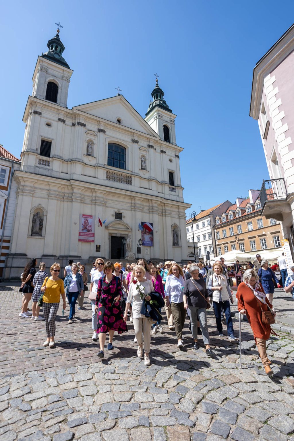 Grupa ludzi przed zabytkowym kościołem.
