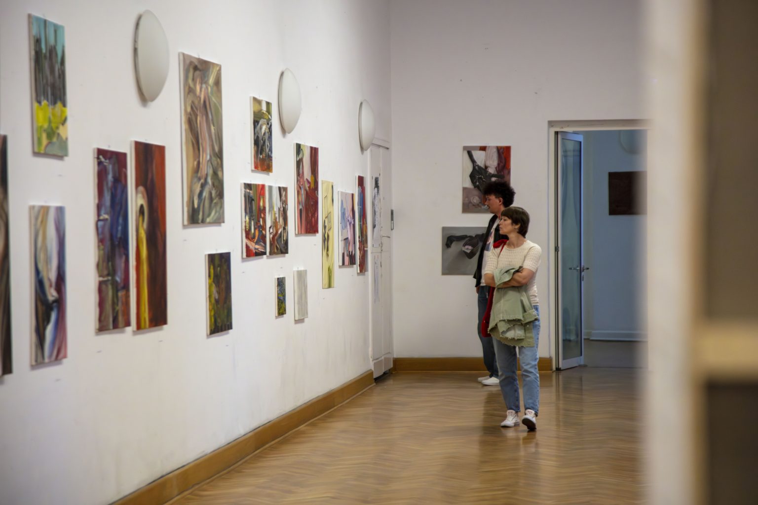 Dwie kobiety oglądają obrazy zawieszone na ścianie