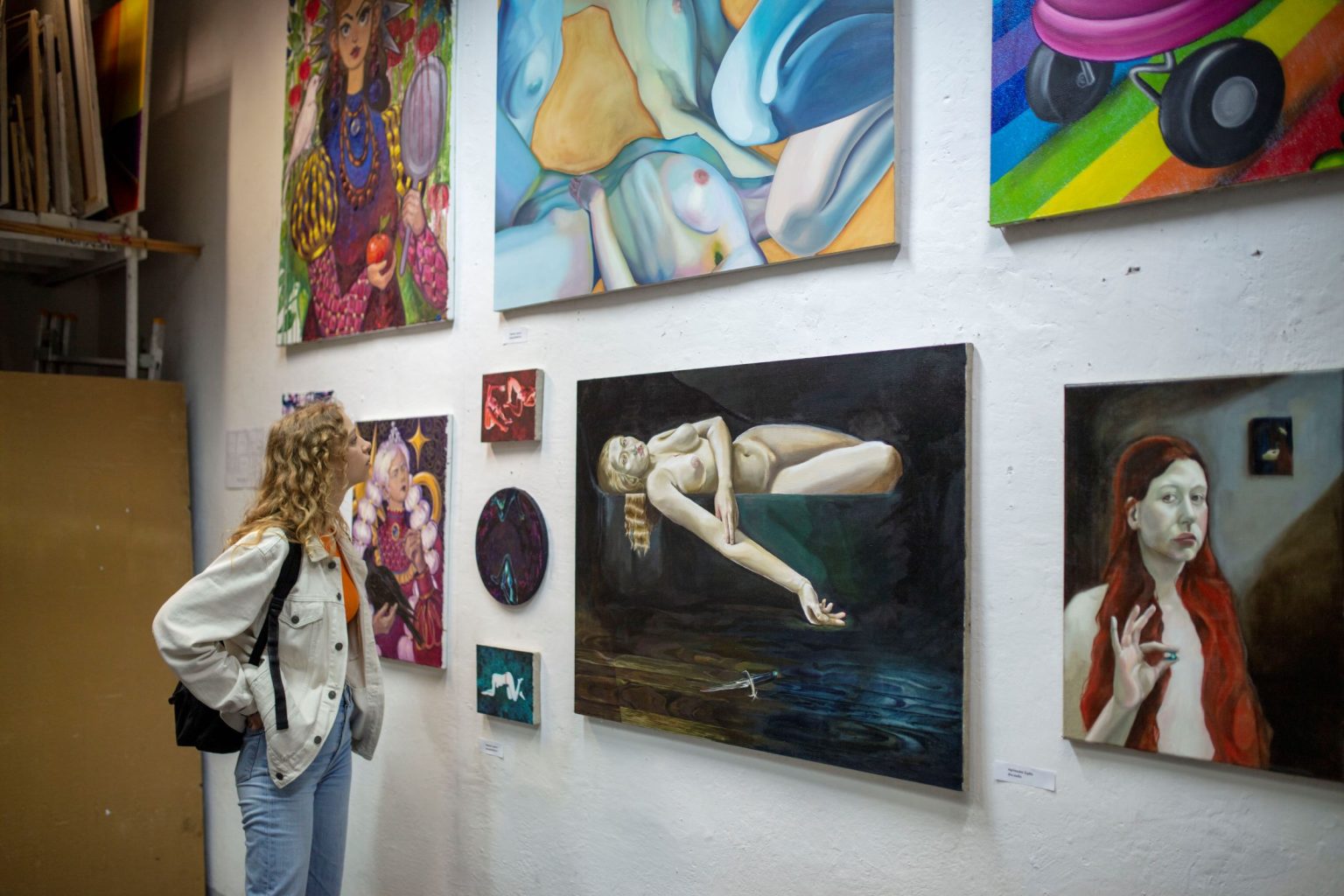 Kobieta obserwuje obrazy zawieszone na ścianie