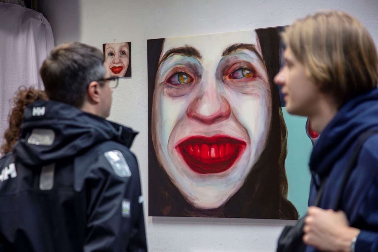 Mężczyźni obserwują obraz przestawiający twarz kobiety