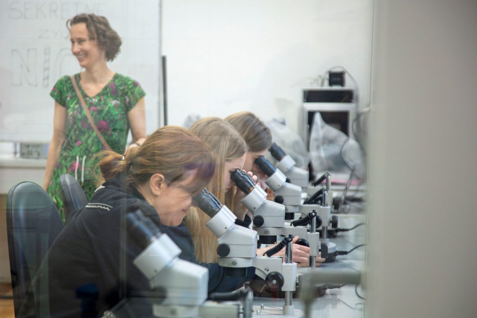 4 kobiety siedzące przy mikroskopach