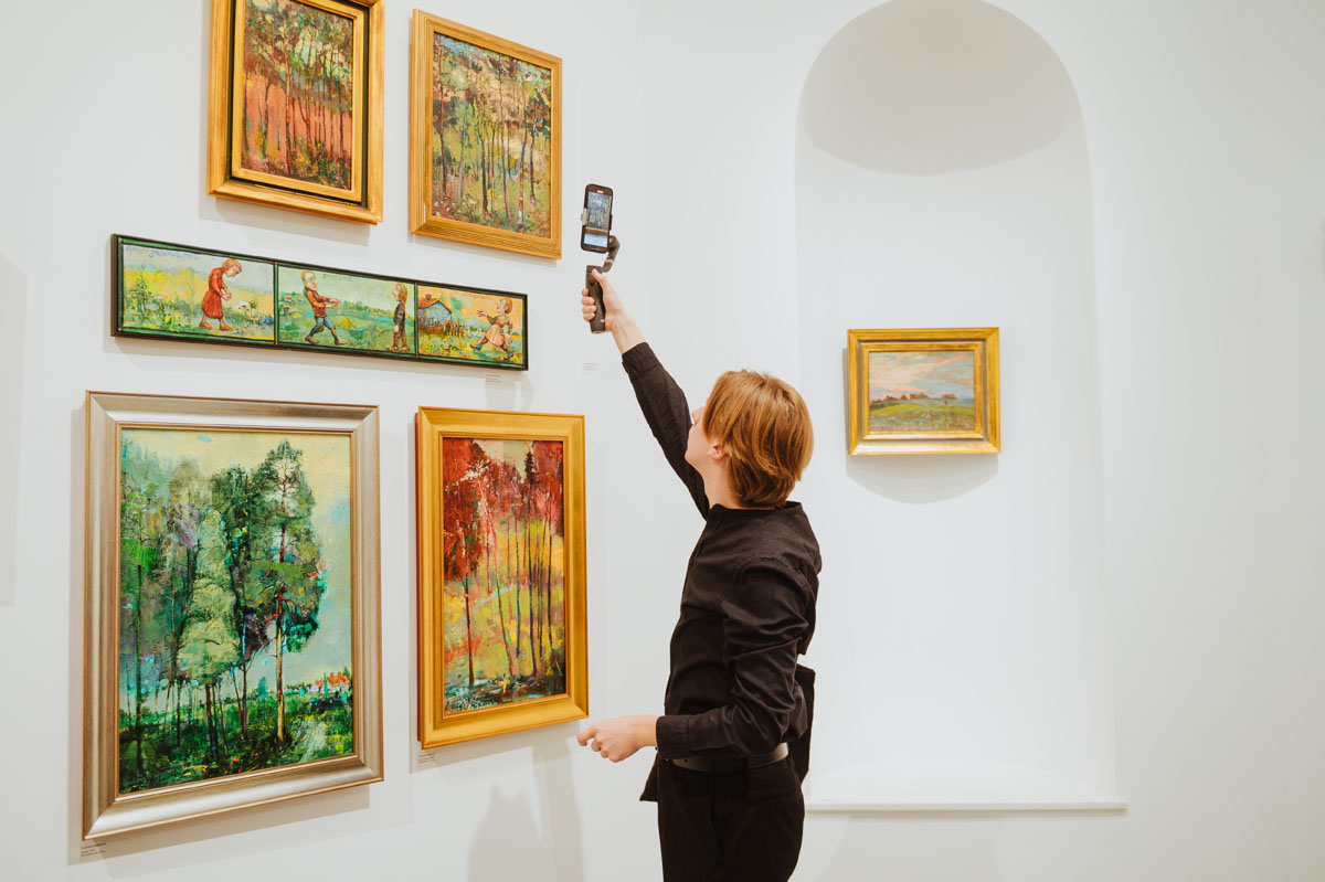 Młody człowiek fotografuje smartfonem obrazy