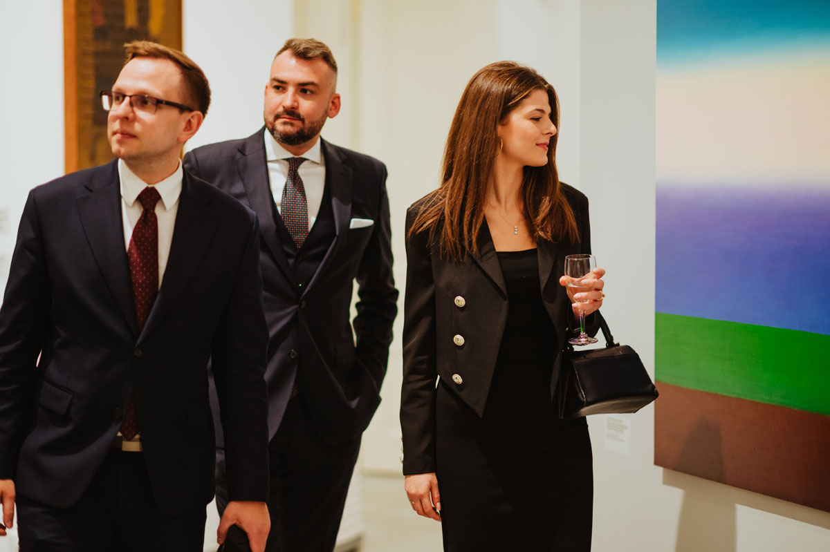 Osoby zwidzające wystawę. Kobieta ogląda obraz