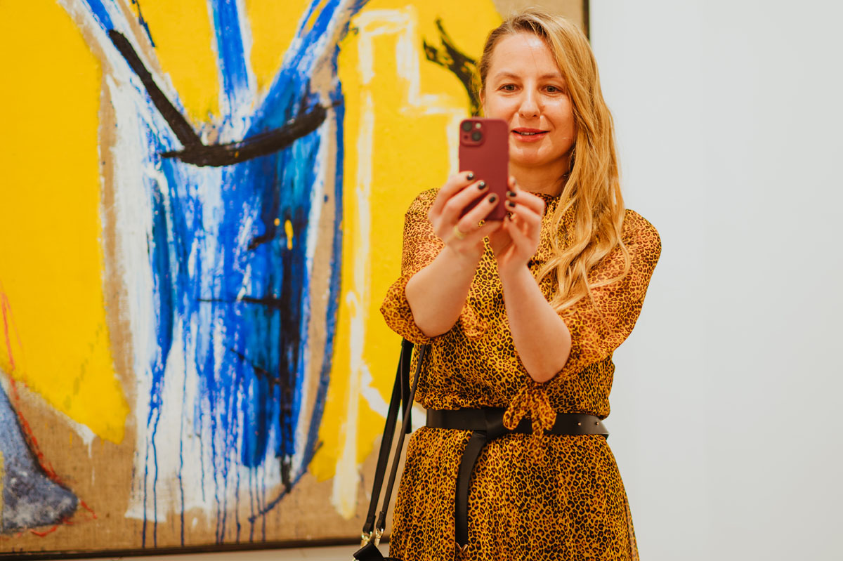 Kobieta robi selfi na tle obrazu