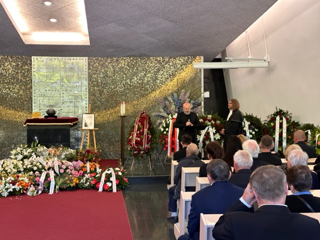 Wnętrze sali domu pogrzebowego. Przemawia Rektor Błażej Ostoja-Lniski