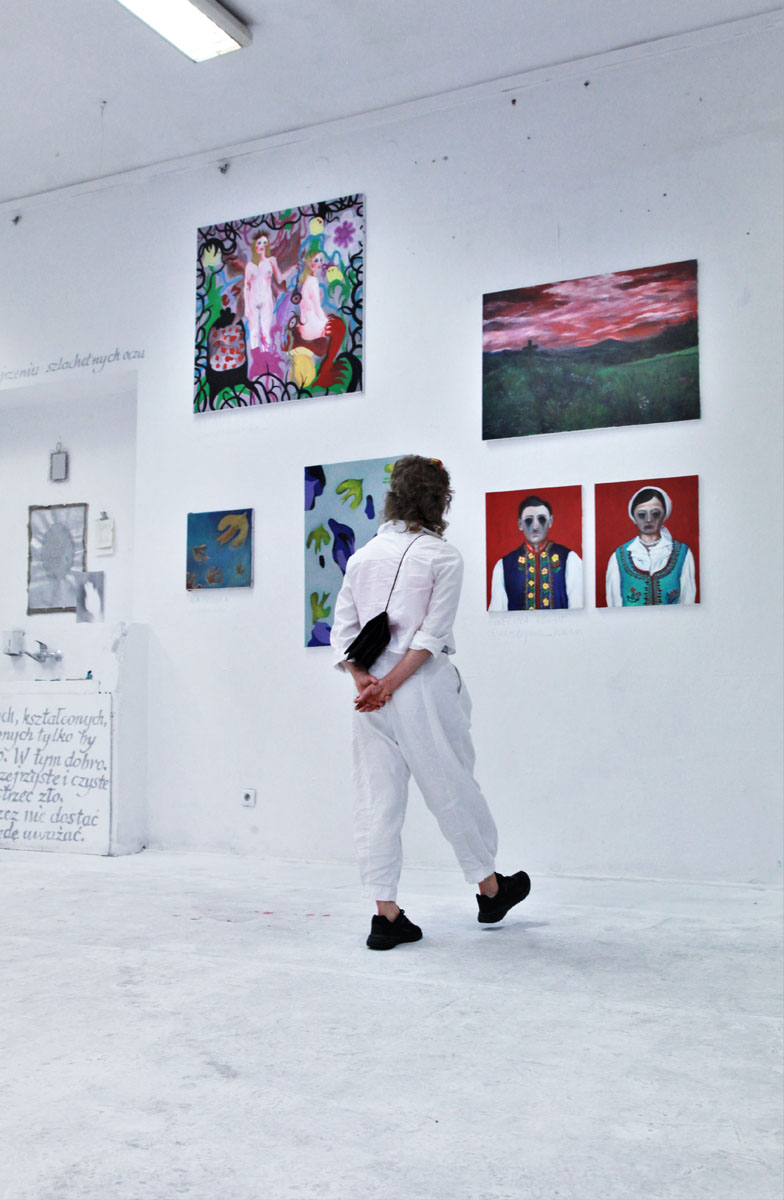 Ubrana na biało postać w przestrzeni wystawowej