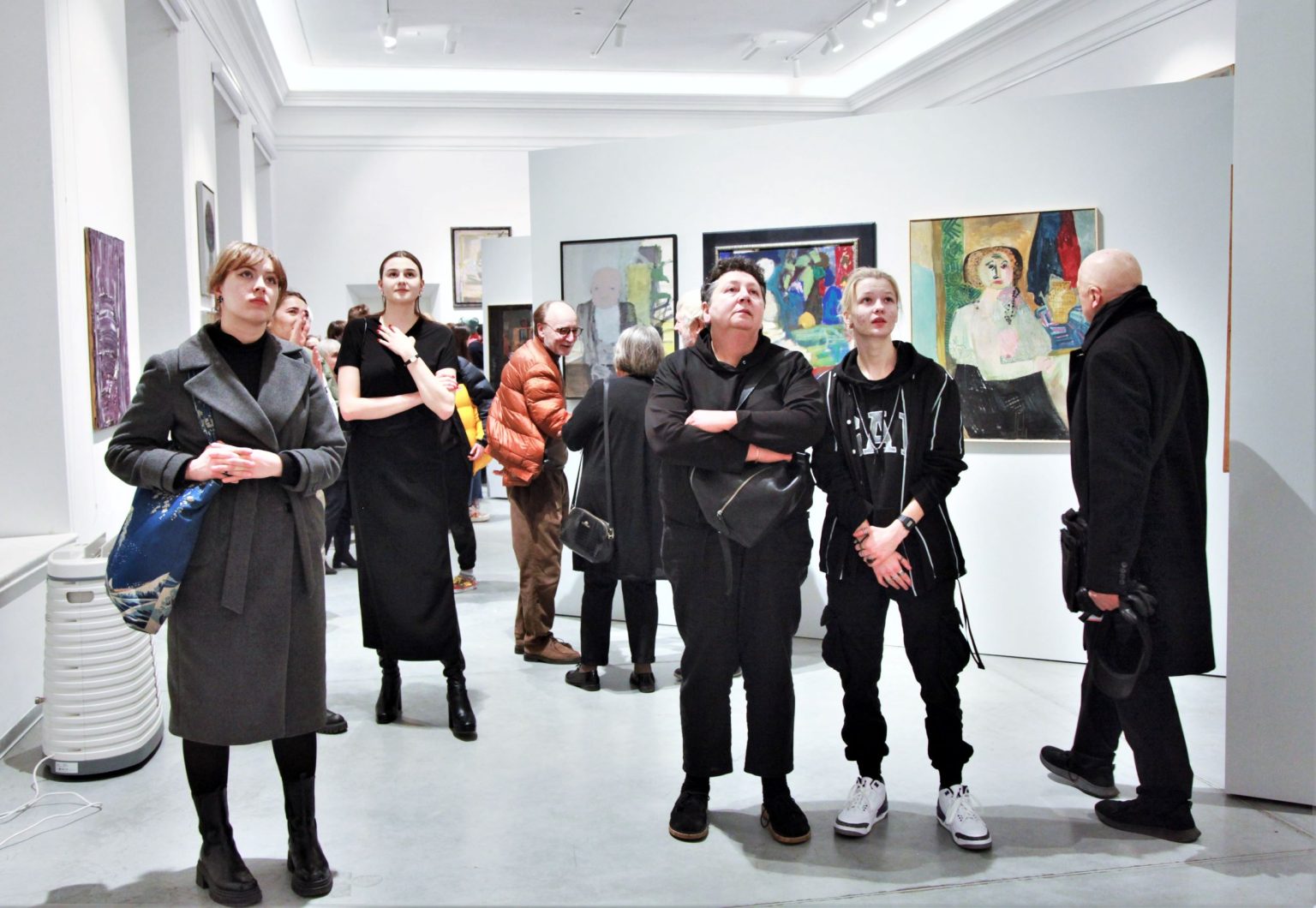 Grupa uczestników wernisażu w przestrzeni wystawowej.
