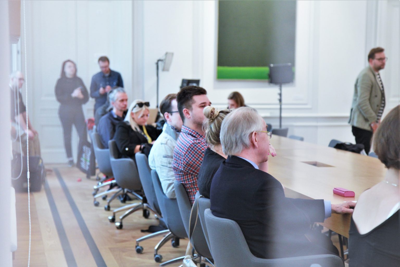 Przy stole siedzą dziennikarze.