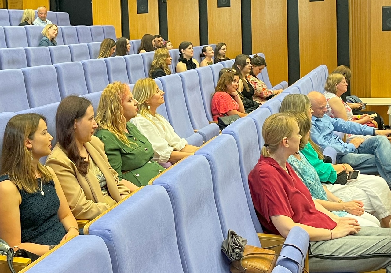 Zbliżenie na publiczność na widowni auli w trakcie ceremonii rozdania dyplomów