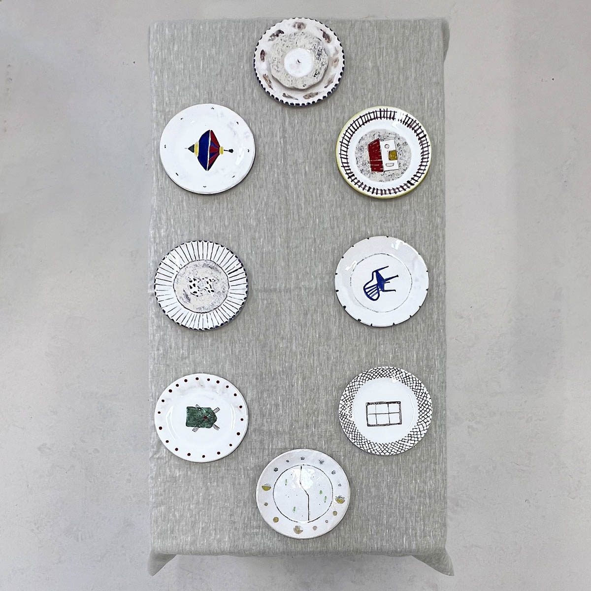 Na blacie stołu stoją ręcznie malowane talerze