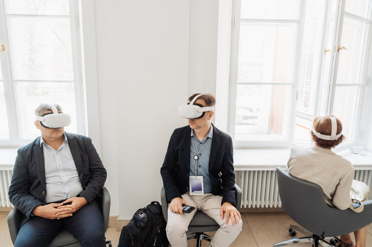 3 osoby w goglach VR oglądają przygotowaną komputerową wycieczkę po pl. Piłsudskiego