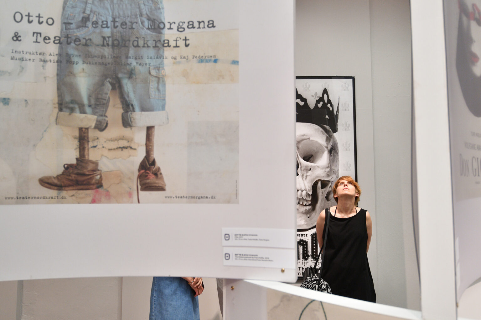 Postać oglądająca plakaty na wystawie