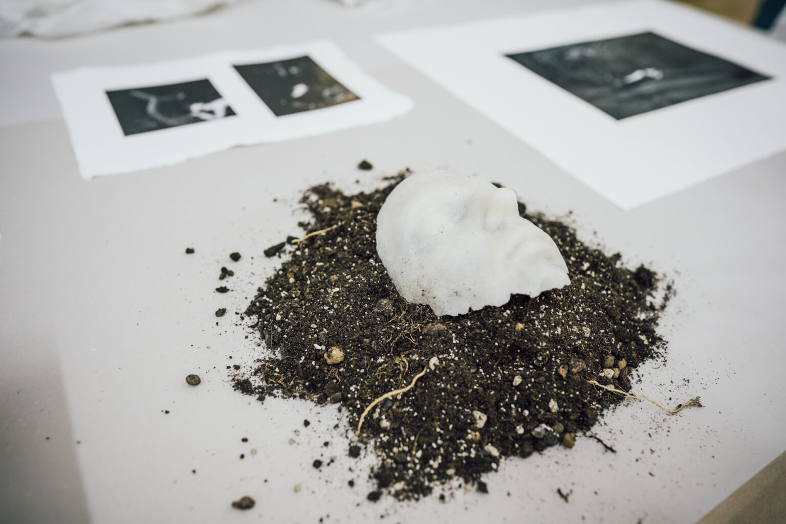 Eksponat przedstawiający twarz na podłożu z usypanej ziemi