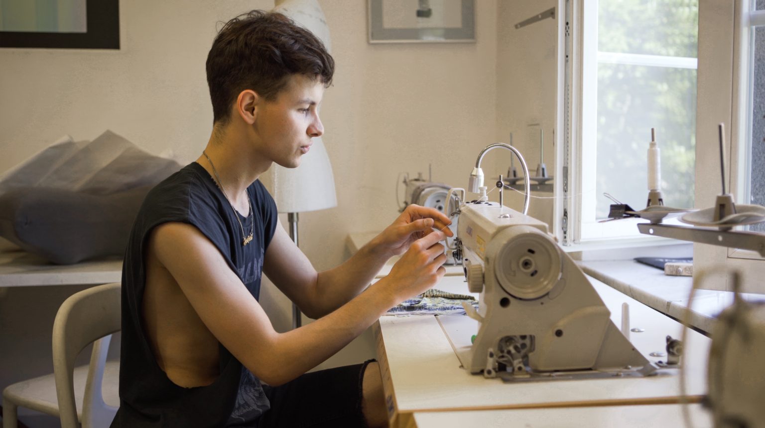 student przy maszynie do szycia