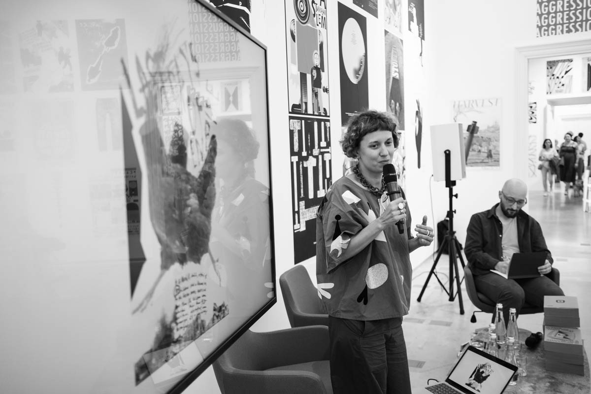 Dasha Podoltseva stoi obok monitora wyświetlającego jedną z jej prac