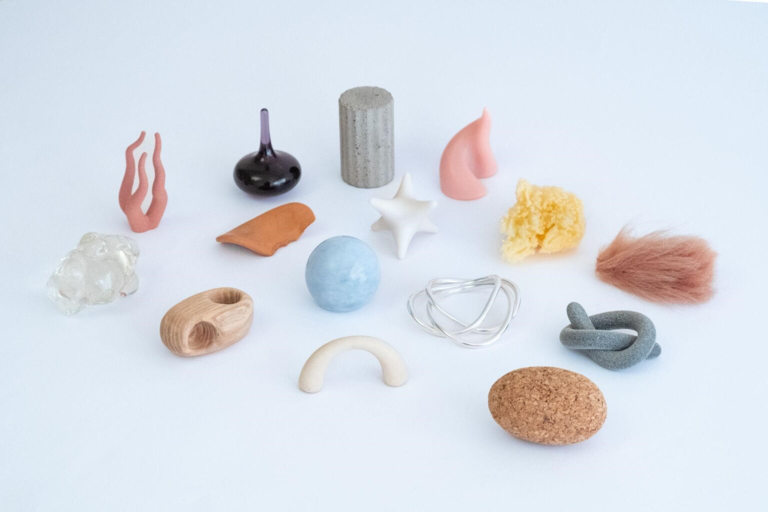 Kolorowe przedmioty o różnej fakturze ułożone obok siebie na białej powierzchni