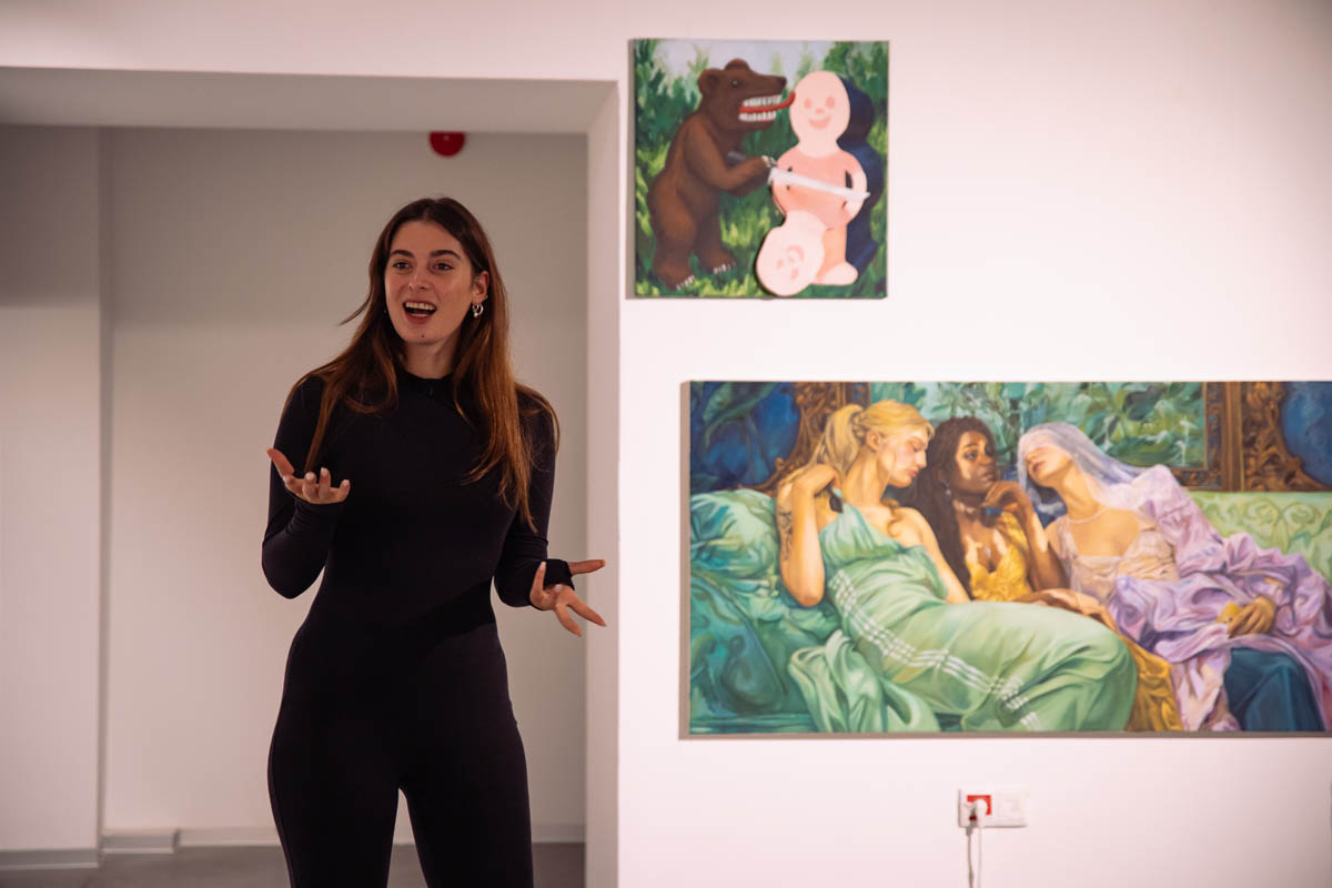 Gestykulująca kobieta na tle wystawy