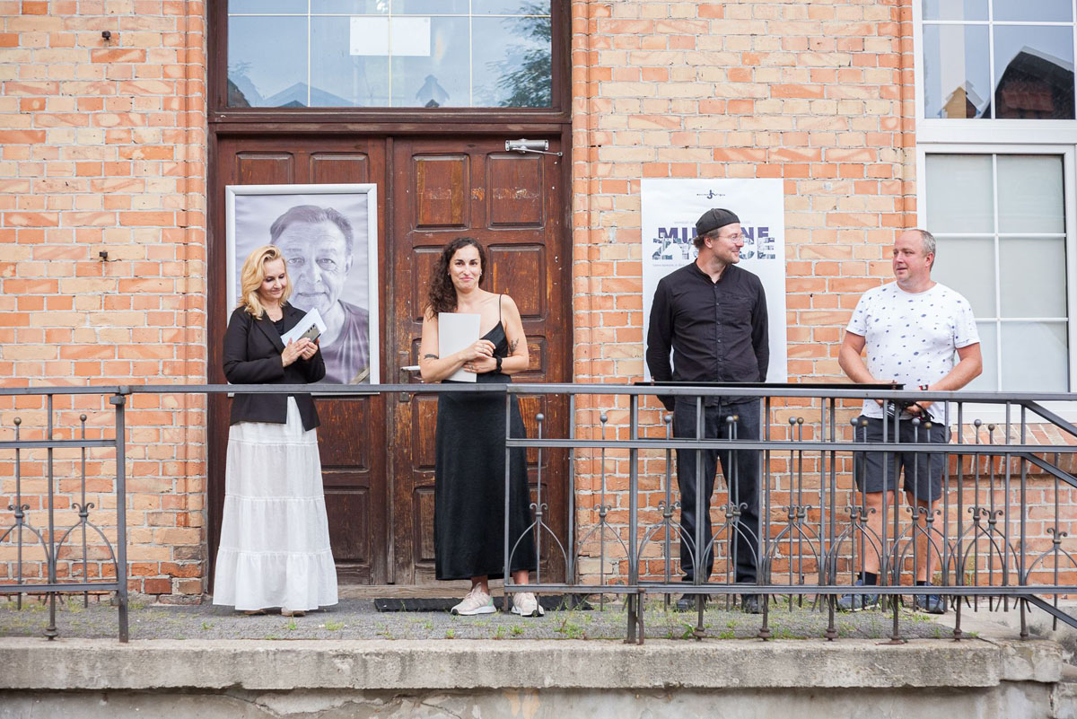 Na schodach przed wejście do Wydziału Rzeźby stoją dwie kobiety i dwóch mężczyzn