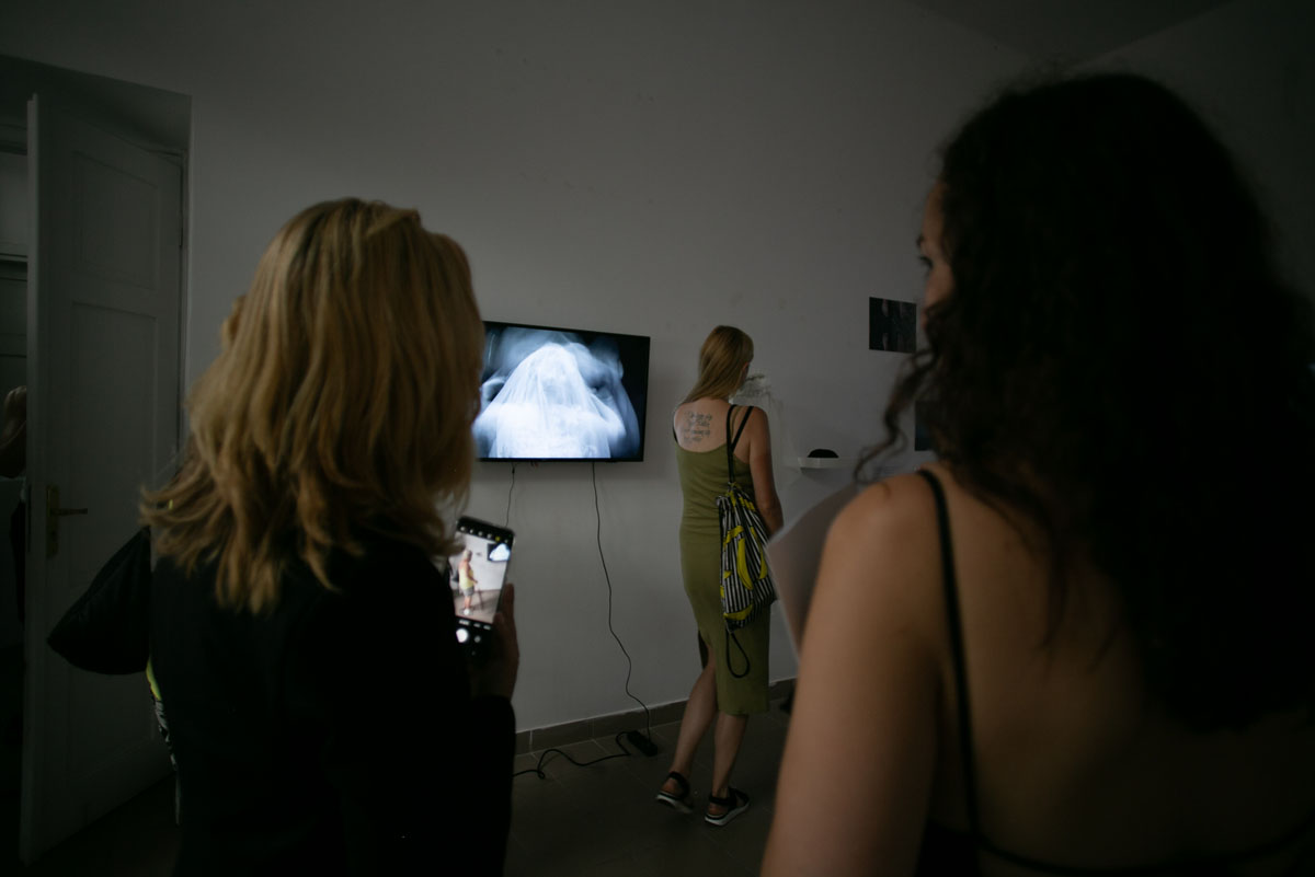 Trzy kobiety w przestrzeni ekspozycyjnej, Dwie z nich obserwują obraz wyświetlany na monitorze