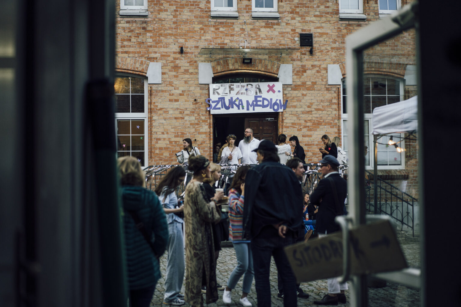 Grupa ludzi przed budynkiem