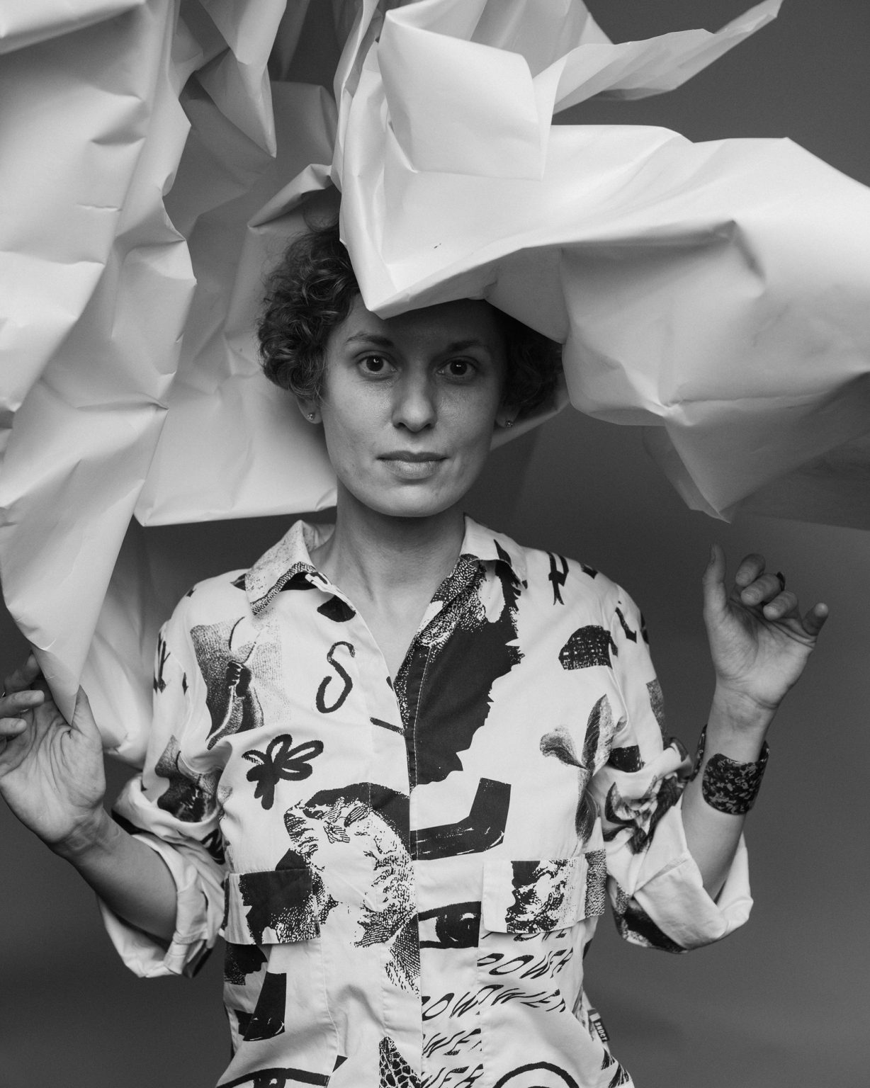 Kobieta dłońmi trzyma nad głową pognieciony rulon papieru