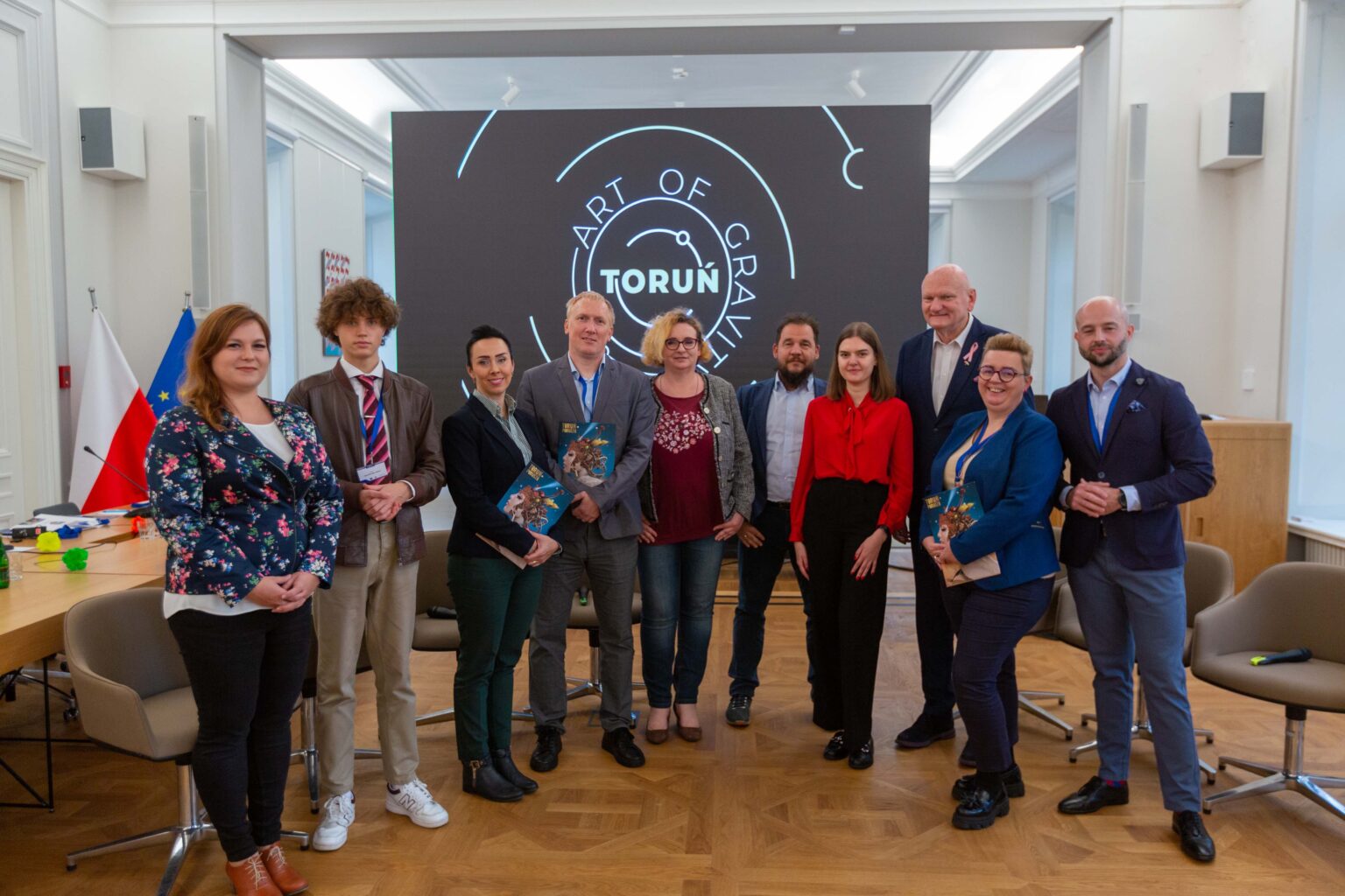 Przedstawiciele Torunia pozują do zdjęcia grupowego w sali senatu ASP