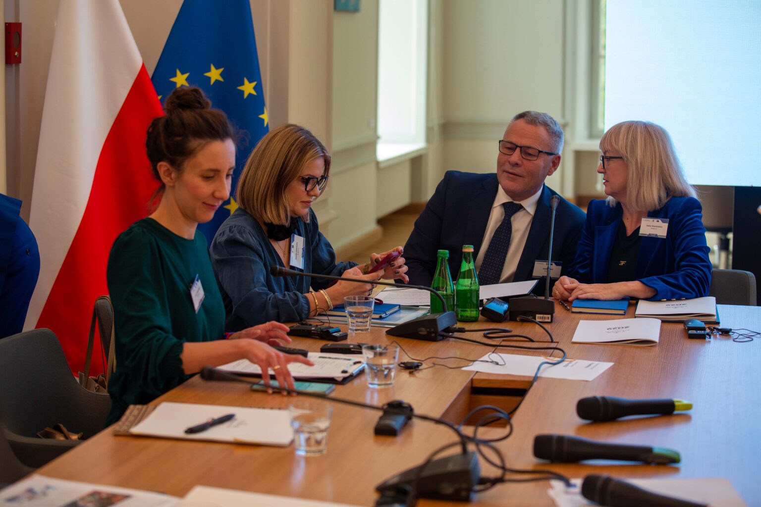 Ludzie rozmawiający przy stole prezydialnym