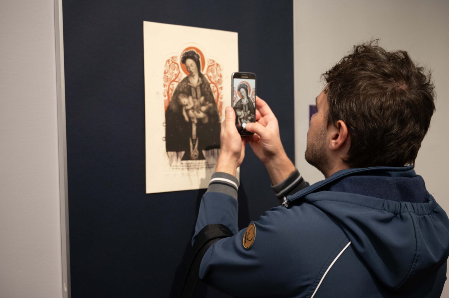 Osoba zwiedzająca robi zdjęcie eksponatowi w muzeum