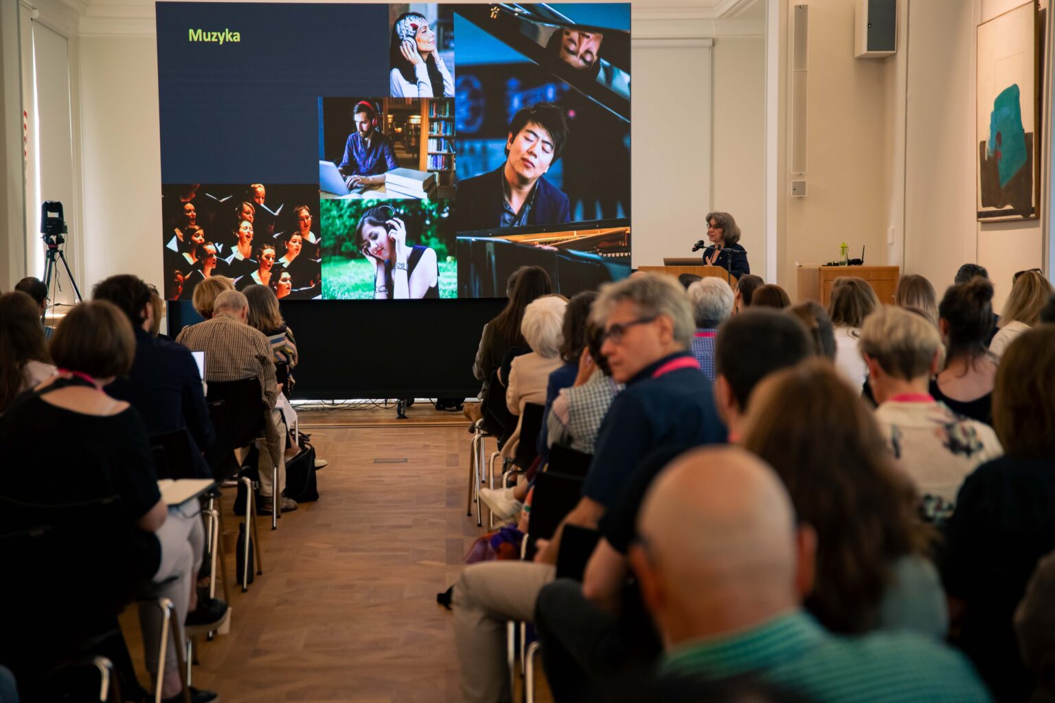 Cała sala słuchaczy i słuchaczek. Prezentacja w tle