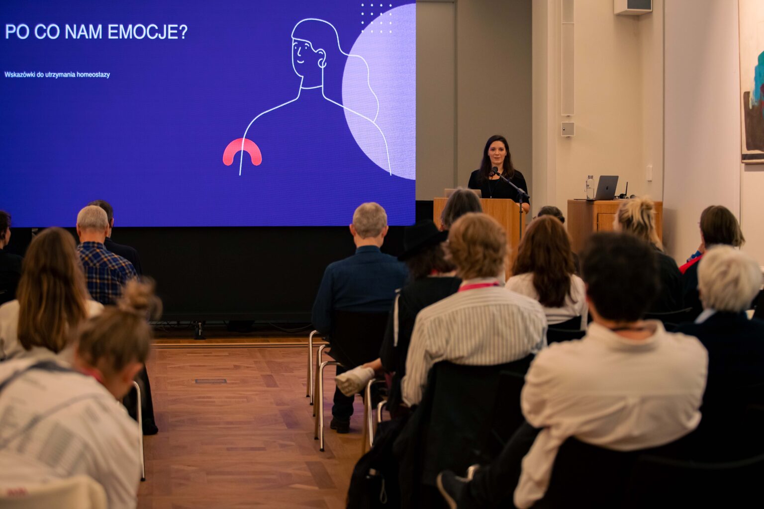 Grupa osób podczas konferencji i prelegent