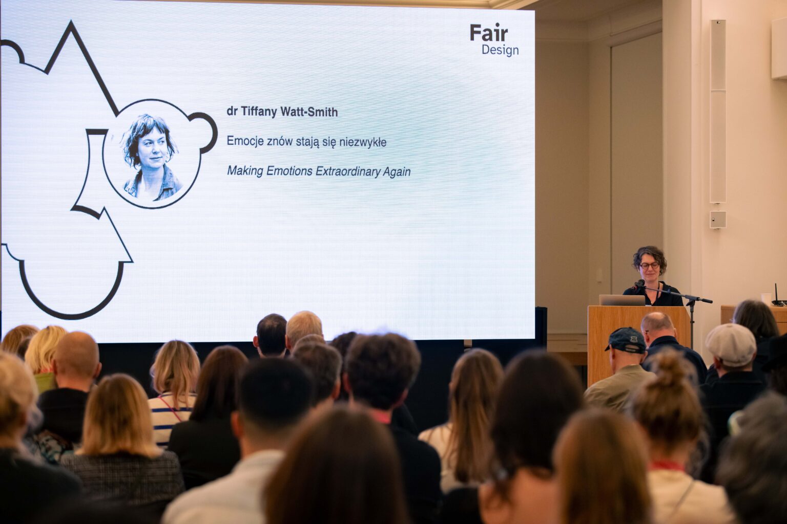 Grupa osób podczas konferencji i prelegent na mównicy