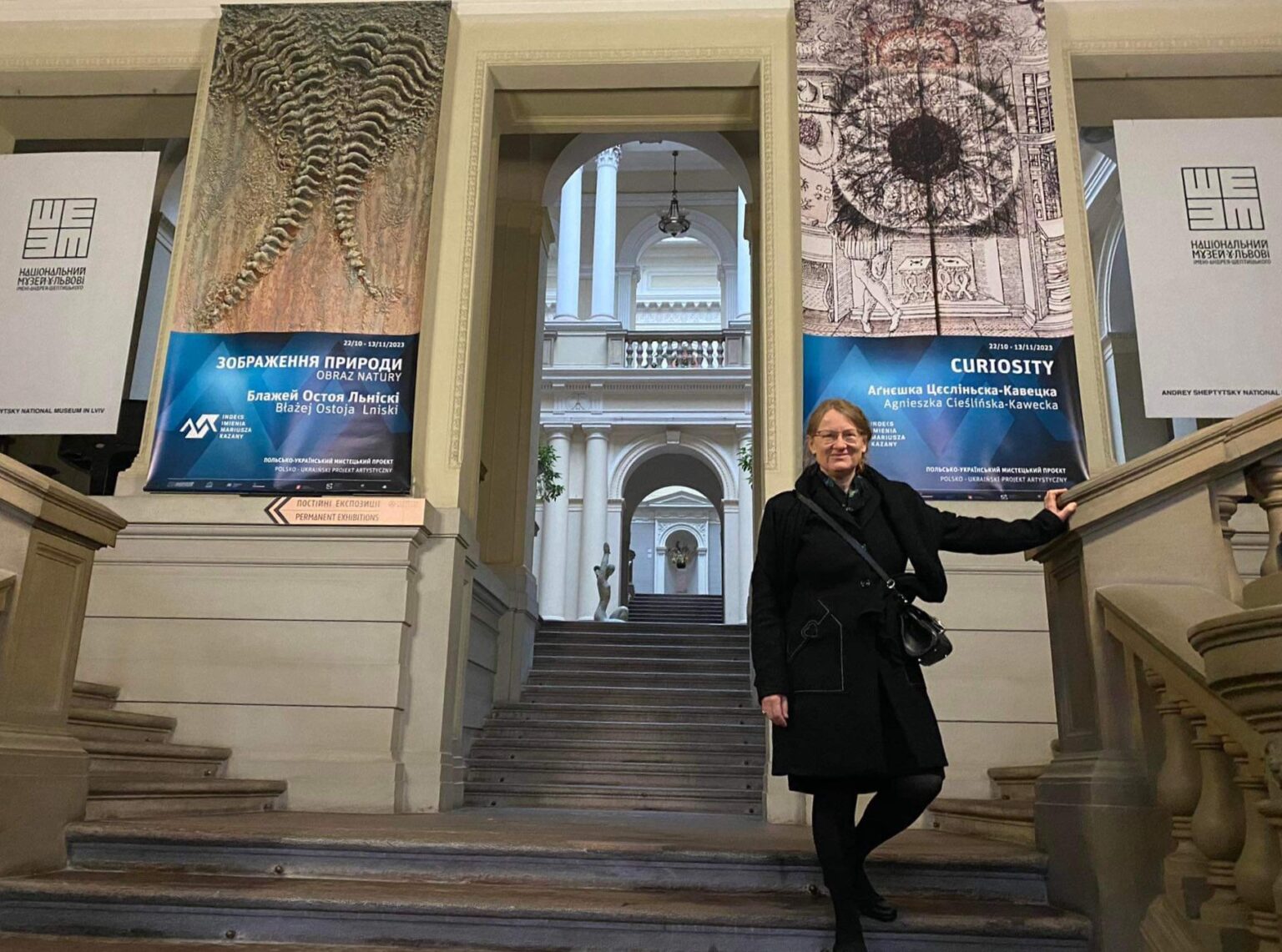 Kobieta stojąca na schodach prowadzących do budynku muzeum