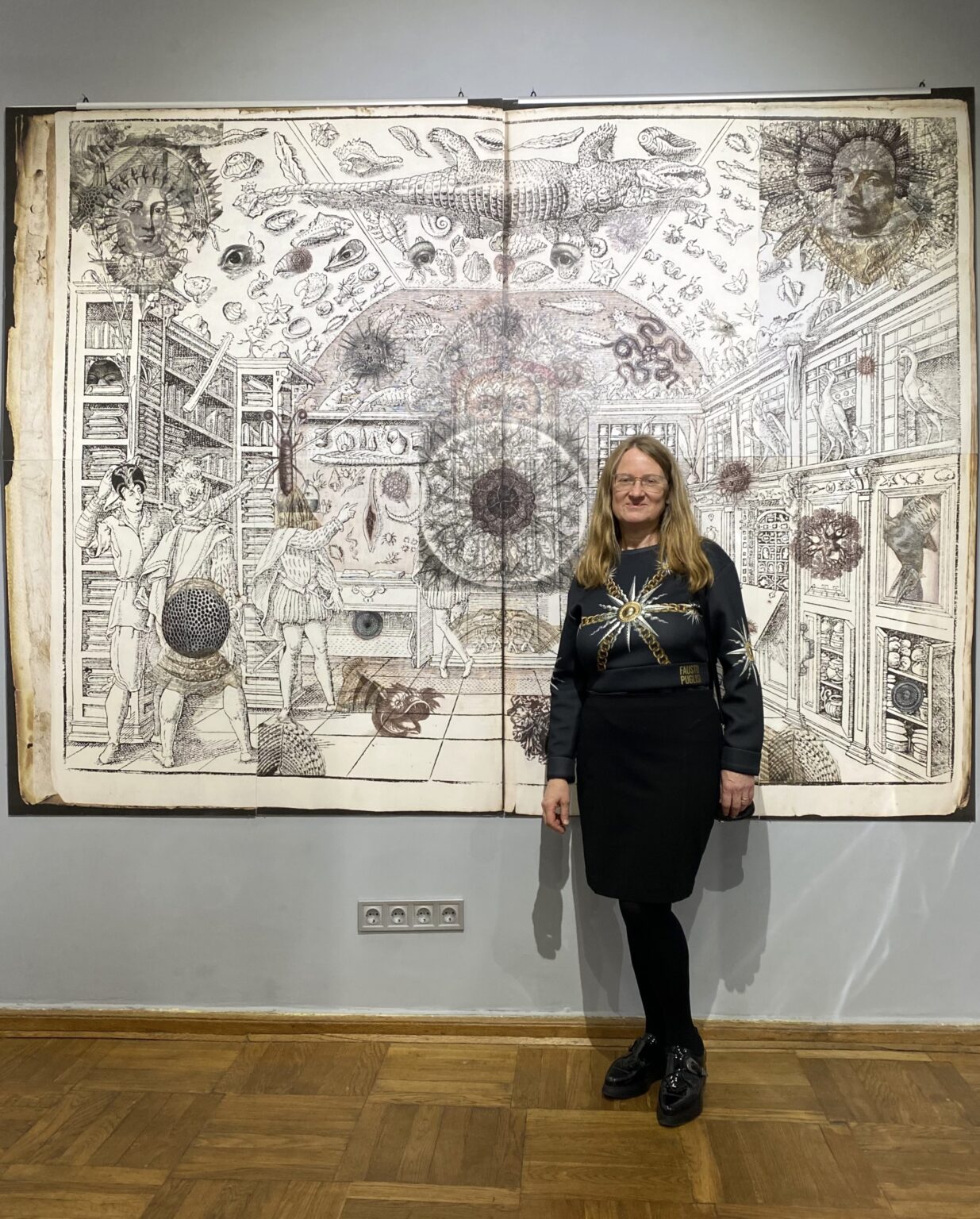 Sylwetka kobiet y na tle eksponatu na ścianie muzeum