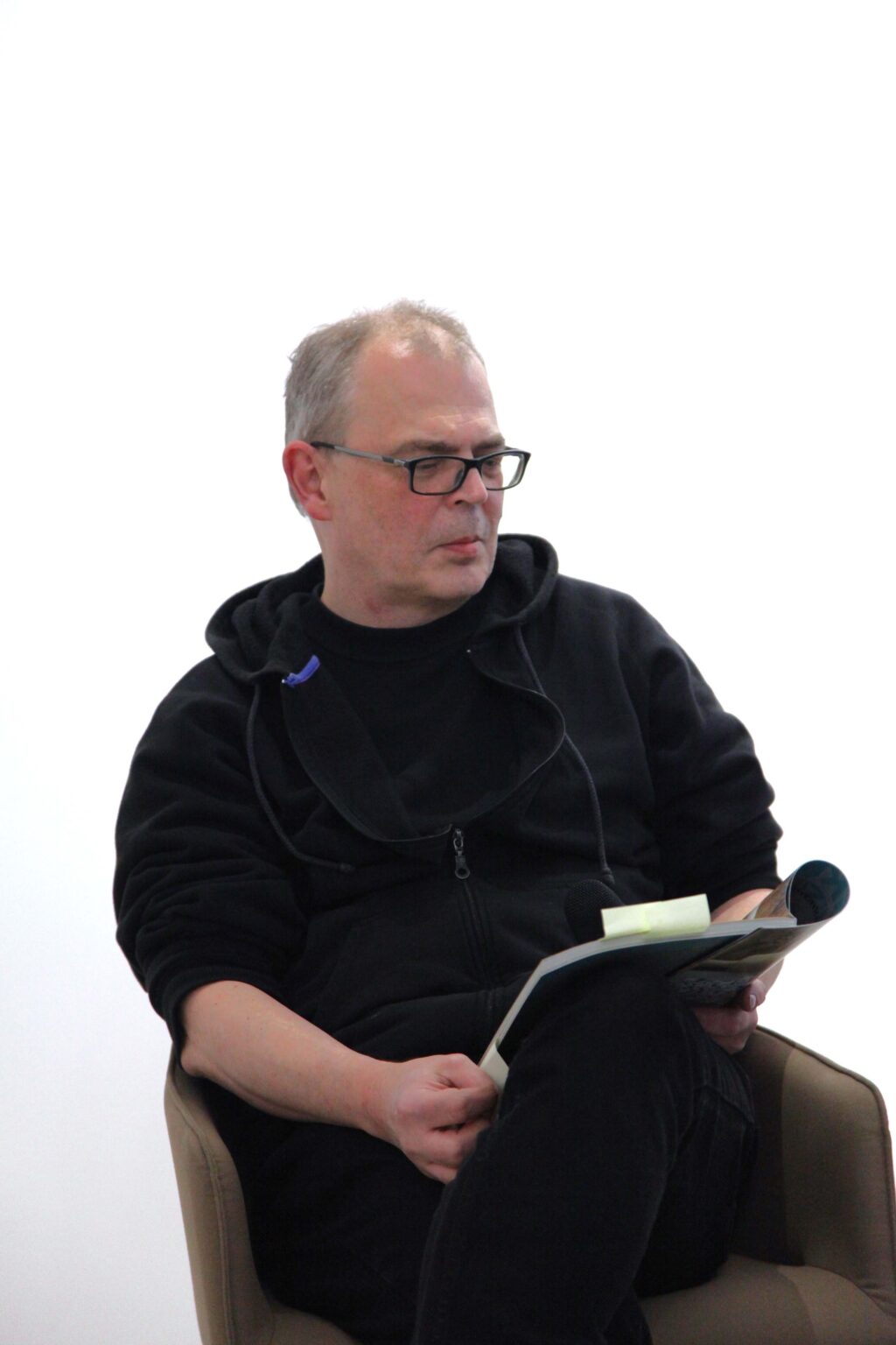 Siedzący mężczyzna trzyma miktrofon