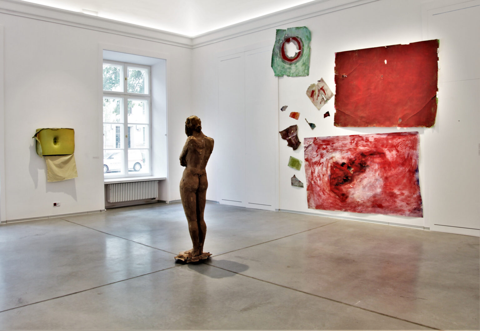 Rzeźba przedstawiająca postać kobiety ustawiona na środku sali wystawowej.