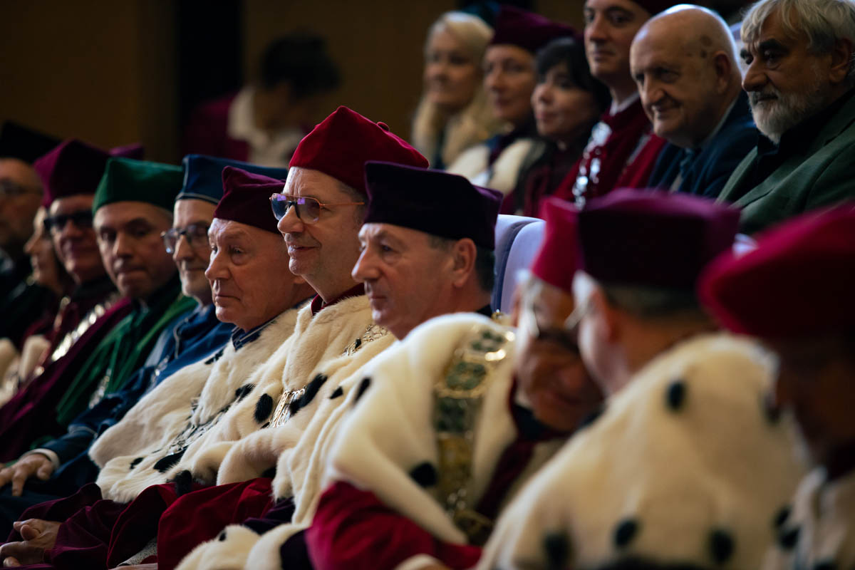 Grupa osób w uroczystych togach i insygniach akademickich