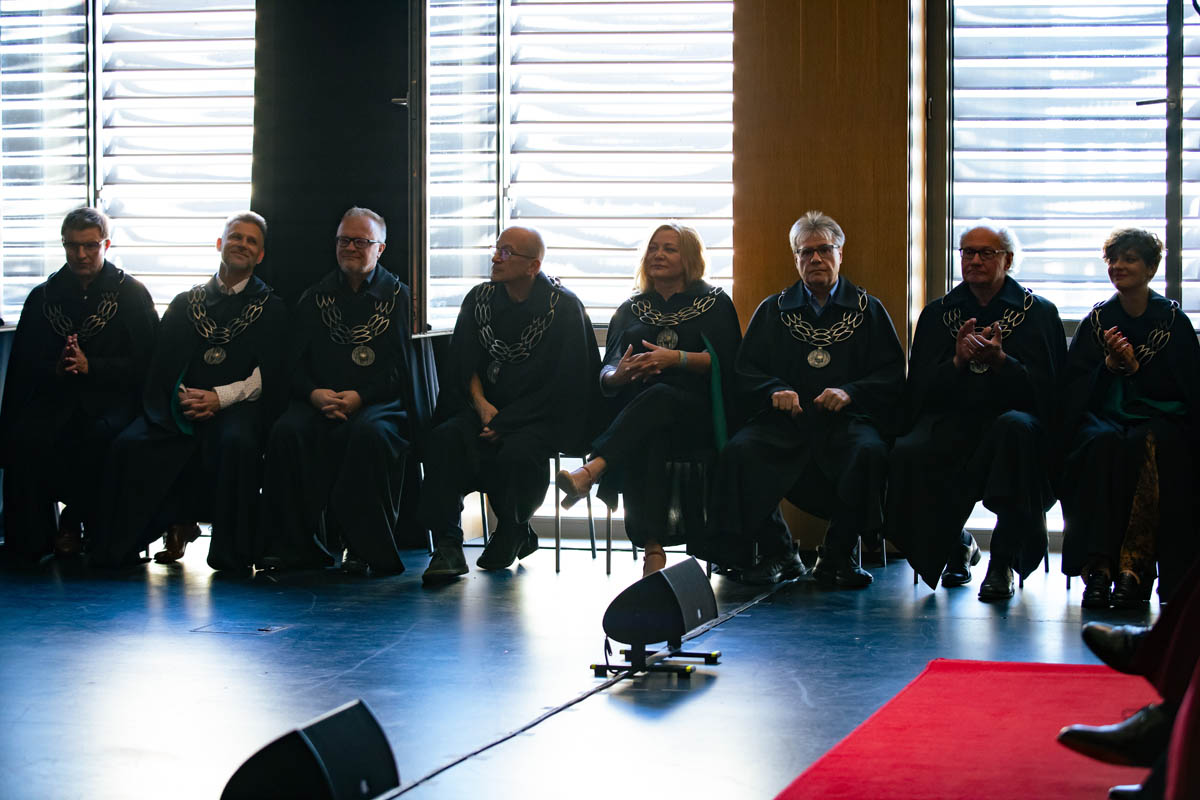 Grupa osób w uroczystych togach i insygniach akademickich