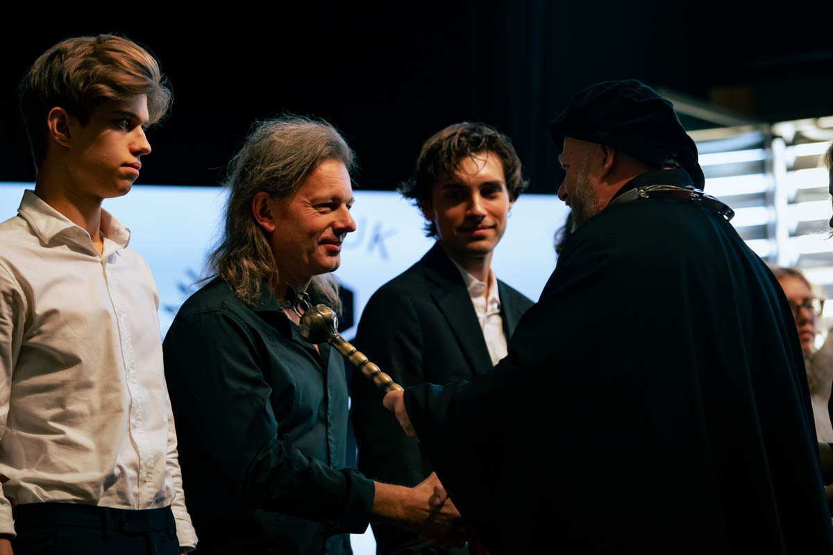 Mężczyzna odznaczający innego mężczyznę stojącego w rzędzie osób