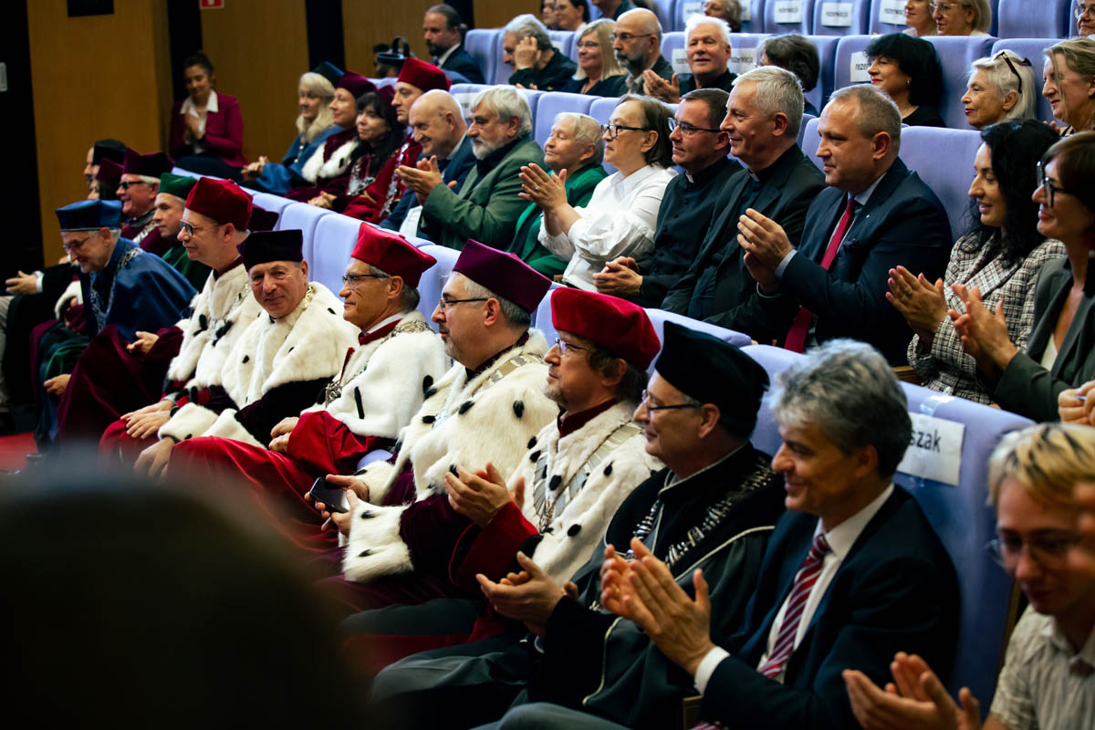 Grupa osób w uroczystych togach i insygniach akademickich