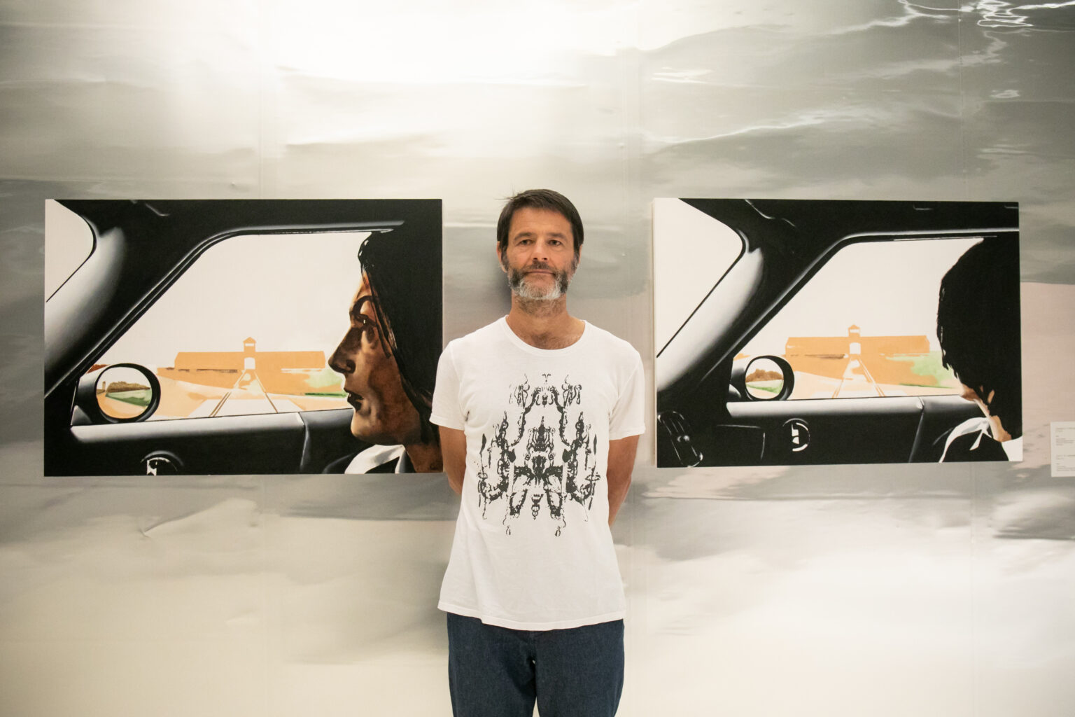 Mężczyzna stojący pomiędzy obrazami